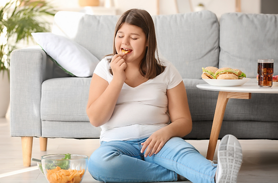 niña con sobrepeso comiendo comida chatarra